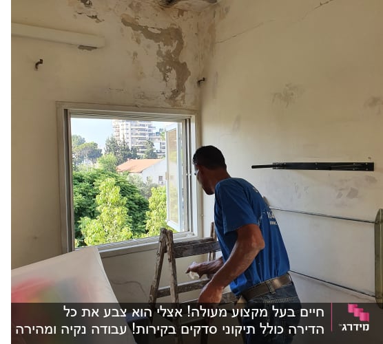 אדם צובע קיר עם סולם וחומרי צביעה